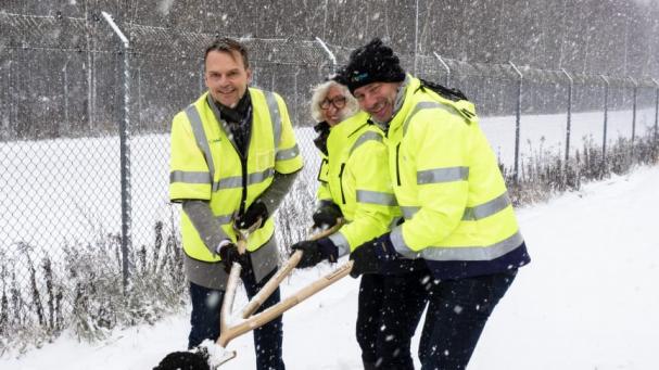 Peter Danielsson, Eva Holm och Ulf Molén tar första spadtaget för NSR:s biokolanläggning medan snön yr.
