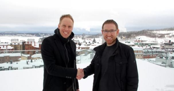 Mattias Lindberg, &Ouml;vik Energi och Martin Gidlund, Nordek, skakar hand med &Ouml;rnsköldsvik i bakgrunden.